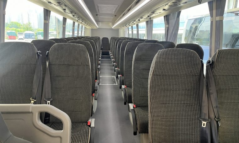 Passenger seats inside a BCI Cruiser bus arranged in rows along the aisle.