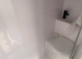 2022 Titan Blackhawk Family 490 interior bathroom featuring the compact toilet and handbasin.