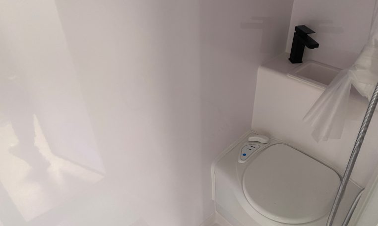 2022 Titan Blackhawk Family 490 interior bathroom featuring the compact toilet and handbasin.