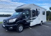 Exterior front and passenger side view of an Auto-Trail F-Line F74 motorhome showing cab, headlights, side profile, and exterior design.